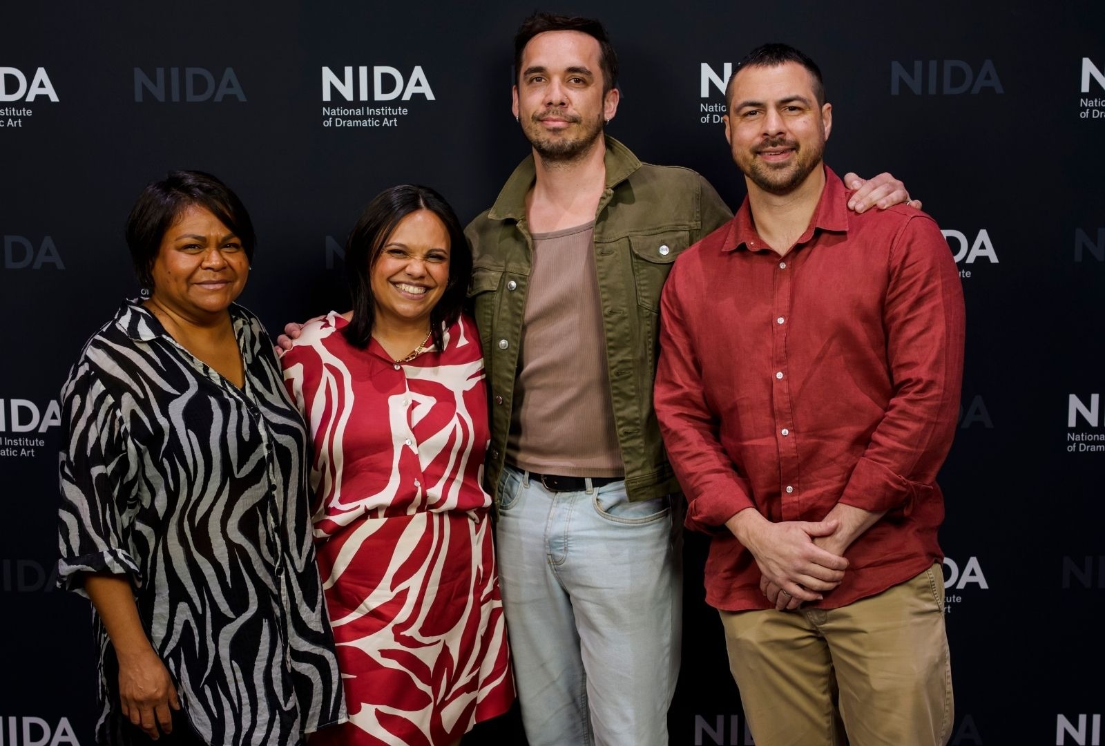Four artists in colourful clothing standing in the NIDA foyer.