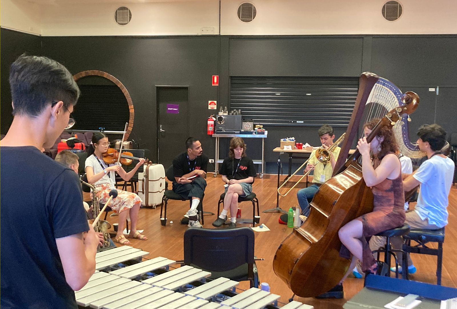 Australian Youth Orchestra practising music in a circle.