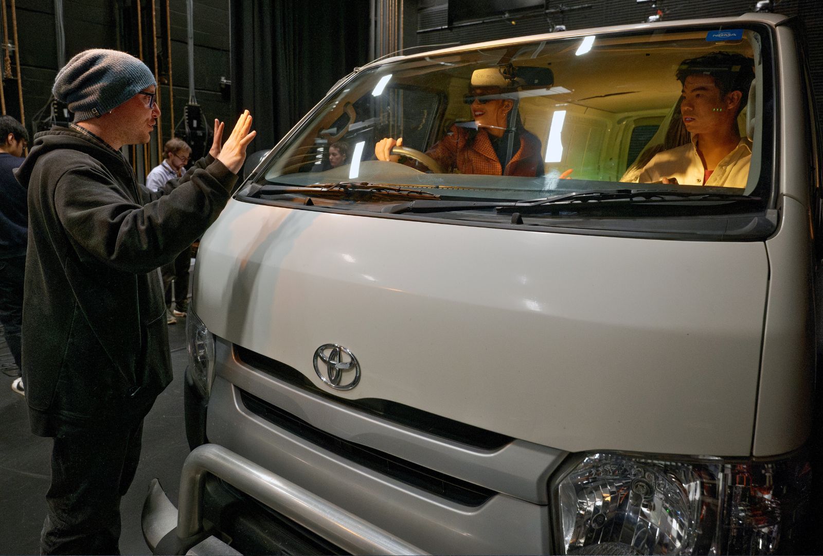 A director directing two people in a car.