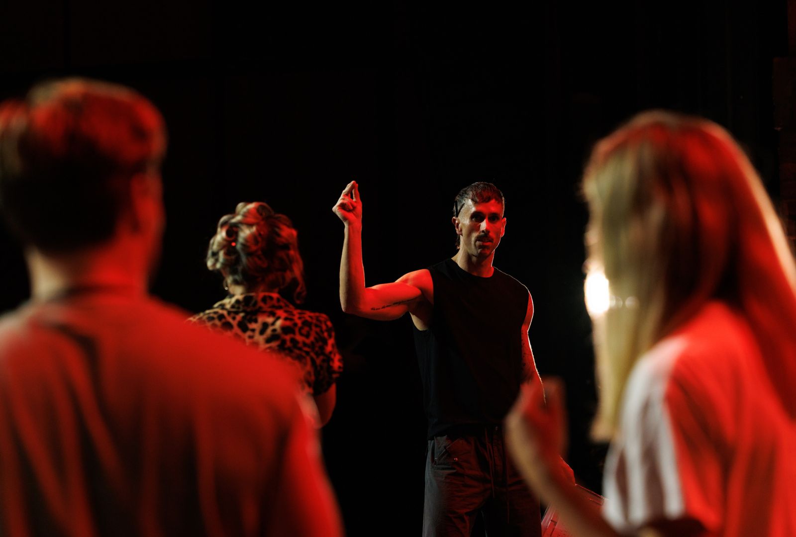 Brendan Yeates directing choreography in a dark room.