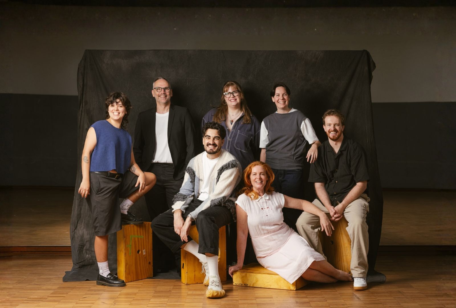Seven people in a classroom sitting on blocks.