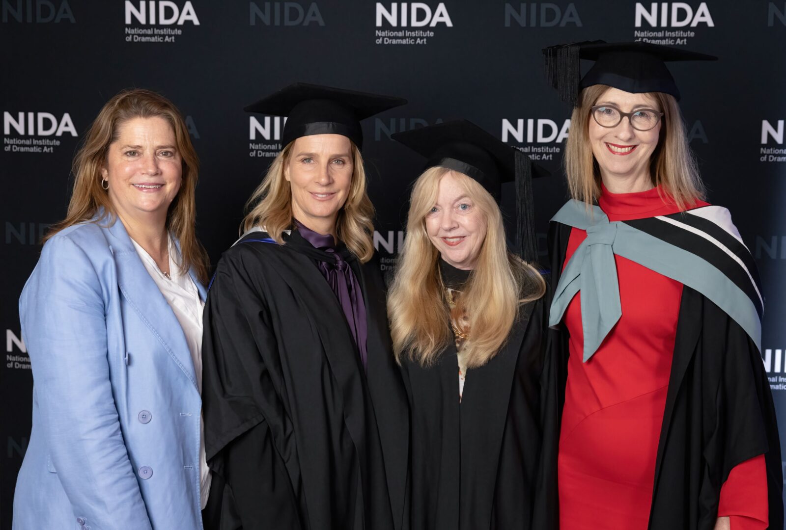 From left to right: Catherine West, Rachel Griffiths, Suzie Miller and Liz Hughes. Four women stand in front of a dark wall with NIDA written across it.