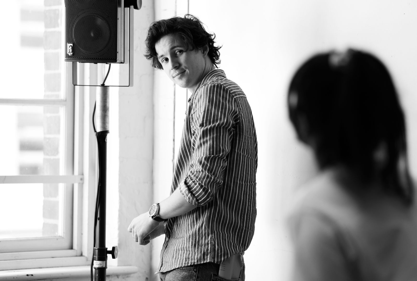 A black and white photo of Josh Hammond looking back over his shoulder.