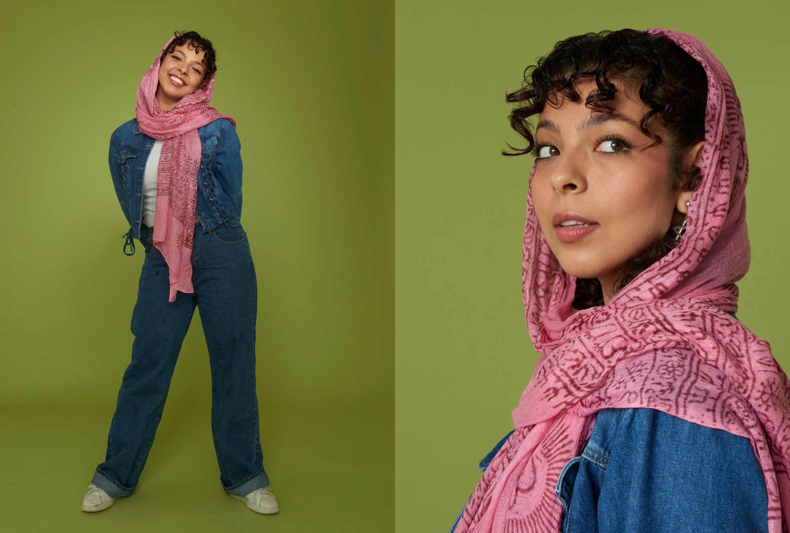 Smiling woman in denim and pink scarf stands confidently against a green backdrop. Mood is joyful and stylish, blending comfort and elegance.